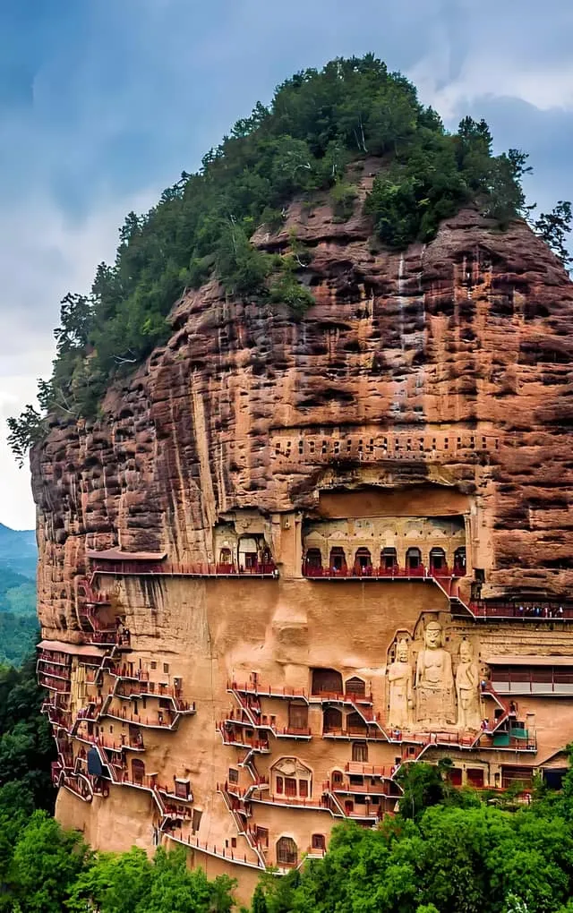The dizzying wooden catwalks clinging to the sheer sandstone cliffs of Maijishan Grottoes with colossal Buddha statues carved into the rock