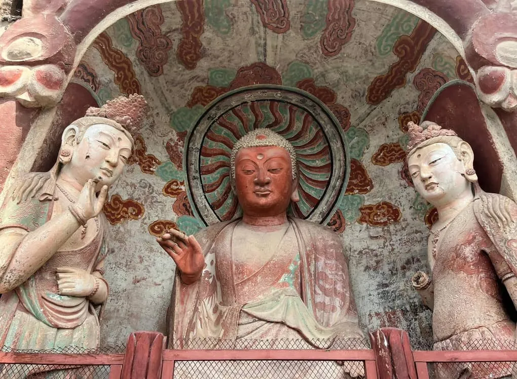 A close-up view of intricate thousand-year-old Buddhist clay sculptures housed inside a cliffside chapel at Maijishan